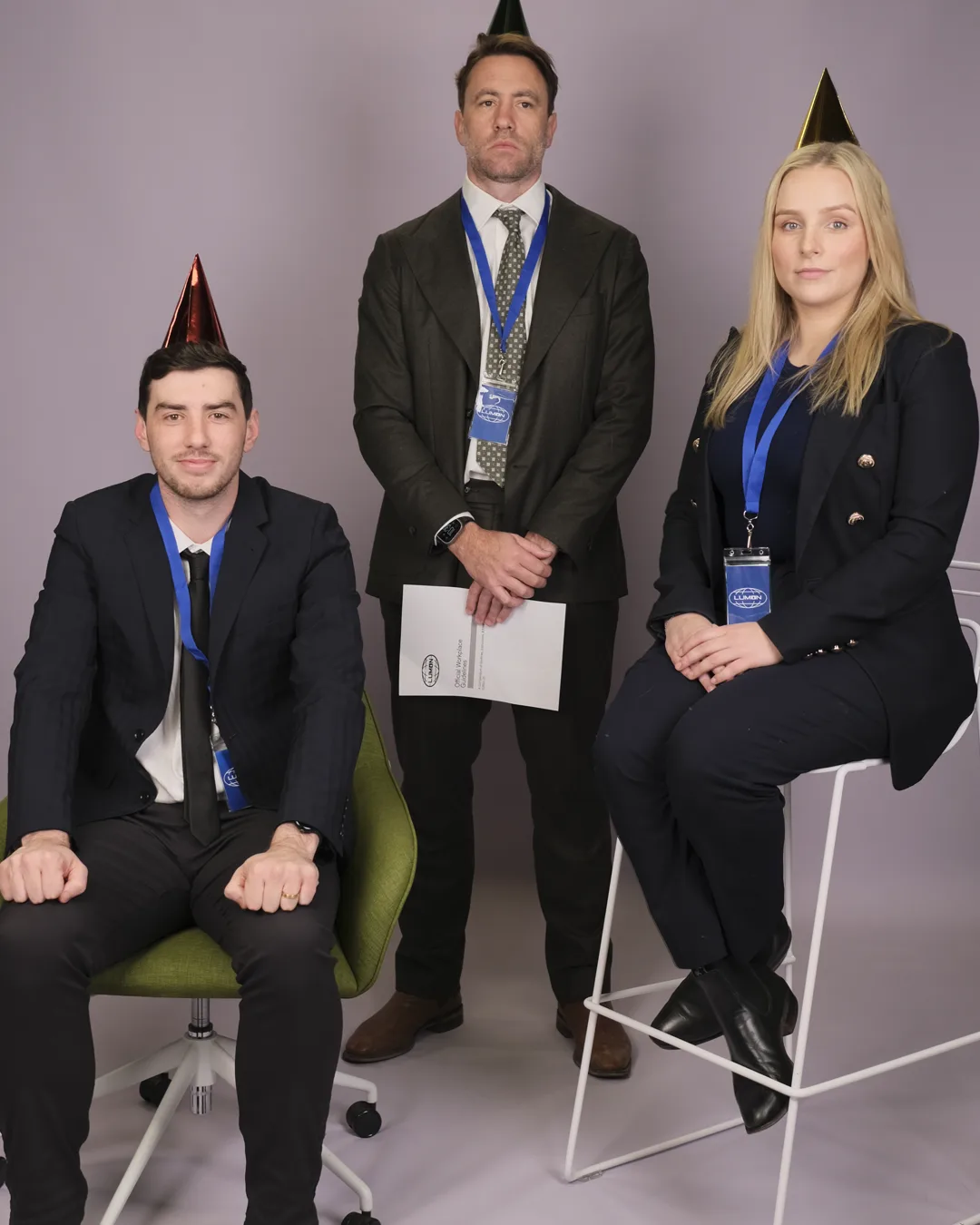 Three Neighbourhood team members in party hats at the office